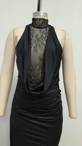 Close-up detail of black halter dress featuring elegant lace panels and ruched waist.