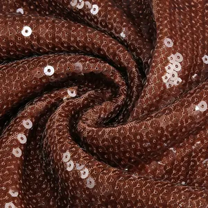 Detaillierte Makroansicht von Textur und Glanz des dunkelkaffeebraunen Paillettenstoffs