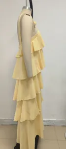 Vista lateral que muestra los volantes detallados de un vestido largo amarillo sin espalda