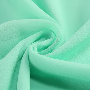 Vista macro que muestra la textura fina y la caída elegante de la tela de gasa verde claro