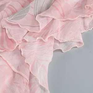 Macro view of soft pink floral print chiffon fabric featuring delicate ruffled edge details.