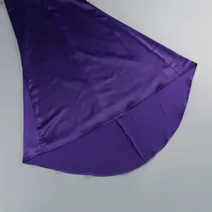 Detalle del elegante dobladillo asimétrico en un lujoso vestido de satén color púrpura.