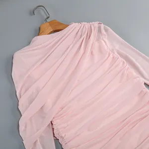 Close-up of pink mesh dress featuring elegant ruched draping and asymmetrical design.