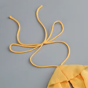 Primer plano del detalle del cuello halter amarillo con volantes de gasa elegantes