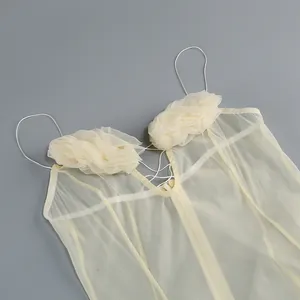 Detalle de un vestido de hada estilo francés con flores 3D y tirantes finos.