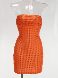 Primer plano de los brillantes diamantes de imitación en este vestido corto naranja ajustado