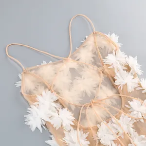 Primer plano de un vestido de playa de malla con apliques florales 3D blancos y tirantes