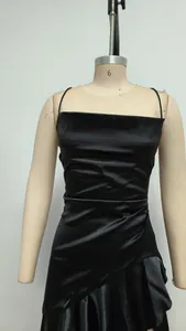Vista detallada de vestido de satén negro con dobladillo con volantes en maniquí