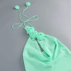 Detalle de un vestido halter verde menta con aplicaciones de rosas de tela en 3D