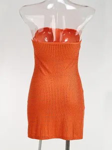 Detalle posterior que muestra los patrones de pedrería en un vestido mini naranja