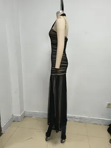 Vista lateral de un elegante vestido largo ajustado de malla negra fruncida en un maniquí