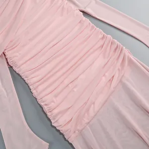 Detailed macro view of pink mesh dress featuring elegant ruching and premium fabric texture.