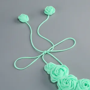 Vista detallada de vestido halter verde menta con elegantes rosas de tela hechas a mano.