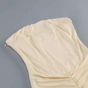 Dettaglio dell'abito a fascia crema con cerniera laterale nascosta e tessuto arricciato.