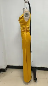 Detalle de perfil de un vestido largo de satén amarillo con fruncidos en un maniquí