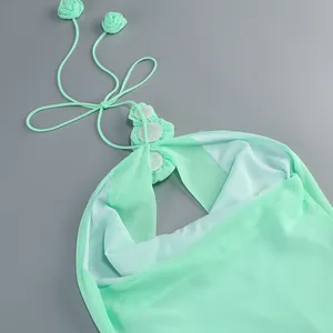 Primer plano detallado de un vestido halter verde menta con elegantes apliques de flores