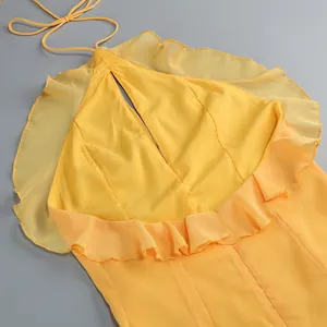 Detalle de un elegante vestido halter amarillo con volantes delicados y abertura