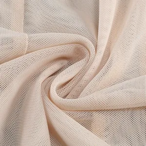 Vista macro della trama del tessuto a rete fine beige che mostra la trama delicata