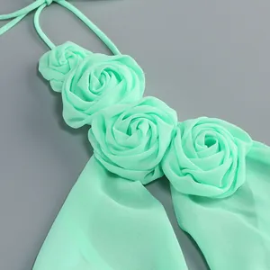 Detalle de rosas de tela verde menta en el escote del vestido tipo halter.
