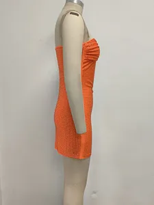 Vista lateral de un sexy minivestido ajustado palabra de honor naranja con pedrería