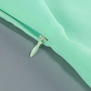 Detalle del cierre invisible de alta calidad en la textura del vestido verde menta