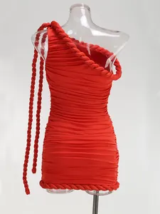 Vista detallada de un vestido ajustado rojo con un hombro y adorno de cuerda trenzada.