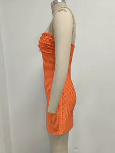 Vista lateral de un mini vestido ajustado naranja sin tirantes con diamantes de imitación.