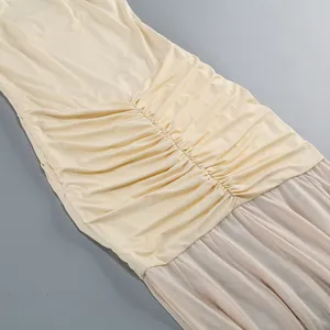 Dettaglio dell'abito a fascia crema arricciato con delicati inserti in rete velata