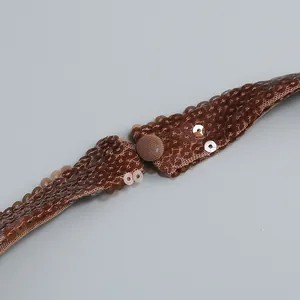 Detailansicht des dunkelbraunen Pailletten-Neckholder-Kleides mit Stoffknopf-Detail