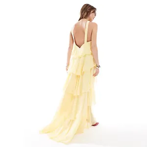 Elegante vestido maxi amarillo con volantes y espalda abierta e irregular de moda
