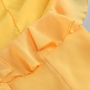 Primer plano macro del elegante borde con volantes amarillos en un vestido de gasa.