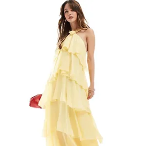 Elegante vestido maxi amarillo con volantes, cuello halter y dobladillo irregular