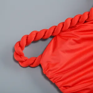 Detalle del tirante de cuerda trenzada roja en un vestido ajustado sexy con pliegues.