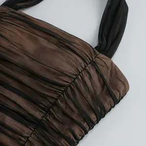 Primer plano de malla negra sobre tela marrón con elegantes detalles plisados ropa.