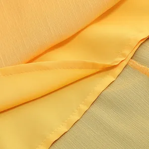 Vista macro de tela de vestido de gasa amarilla con textura elegante y detalle de dobladillo