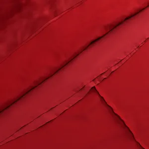 Primer plano del vestido de noche rojo mostrando el forro interno y detalles de costura