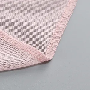 Detailed close-up of fairy pink mesh fabric and fine stitching on a French style dress