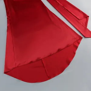 Vista detallada de un elegante vestido de noche de satén rojo con dobladillo asimétrico.