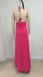 Detalle de espalda de vestido halter con flores 3D en color rosa fucsia