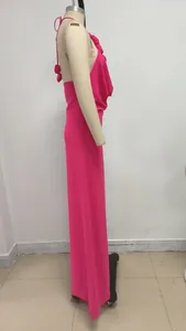 Vista lateral de vestido maxi fucsia con cuello halter y detalle floral en maniquí