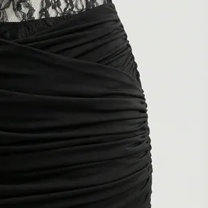Detalle de cerca de los pliegues negros y encaje en un vestido halter sexy