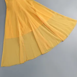 Primer plano del elegante dobladillo de gasa amarilla de un vestido de gala