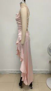Detalle de la textura satinada y el dobladillo irregular con volantes de un vestido.