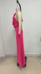 Vista lateral de un vestido largo fucsia con cuello halter y flores en un maniquí.
