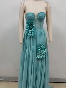 Detailed view of teal tulle evening dress featuring 3D floral accents on a mannequin