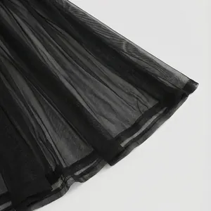 Detalle de primer plano de la tela de malla plisada negra de calidad en un vestido elegante