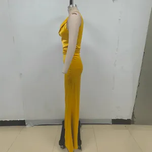 Vista lateral elegante de un vestido largo de satén amarillo plisado en un maniquí de costura.