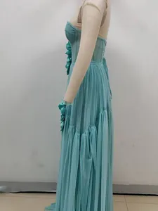 Side profile of a teal tulle dress featuring intricate 3D floral appliqués and pleats