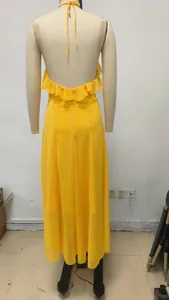 Vista trasera de un elegante vestido largo amarillo con volantes sobre un maniquí