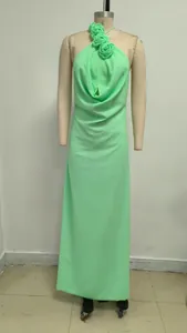 Elegante vestido largo verde menta con cuello halter y flores en maniquí.